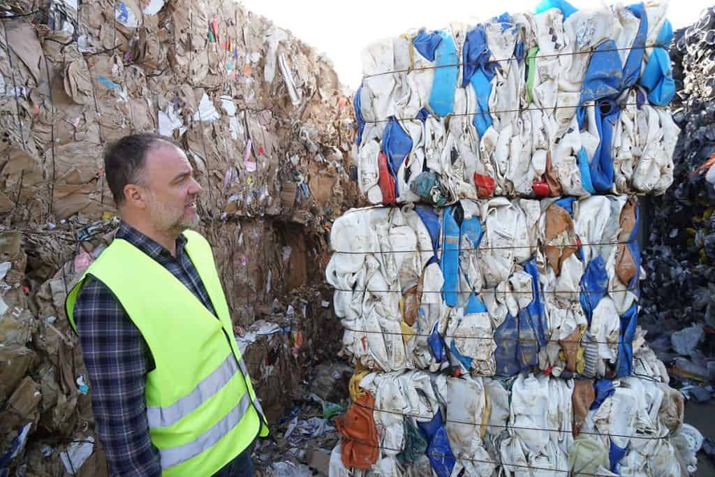 Christian Stridsberg looks att bales of plastic canisters.